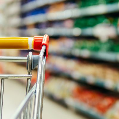 Shopping cart in supermarket. Part of shopping trolley in supermarket aisle. Blurred shelves in grocery store and trolley. Copy space for text or design.