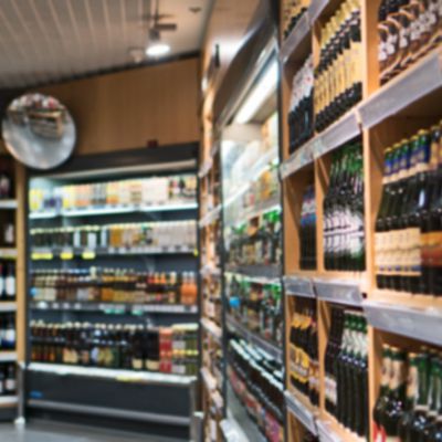 Blurred image of shelves with alcoholic drinks in supermarket.