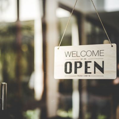 Open sign hanging front of cafe with colorful bokeh light abstract background. Business service and food concept. Vintage tone filter effect color style.