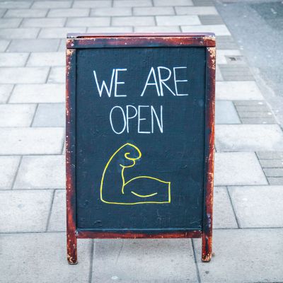 A sign on a board outside a shop informing people that the shop is open. Taken during the Coronavirus London lockdown.