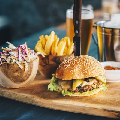 Tasty beef cheeseburger served with french fries, coleslaw salad and beer