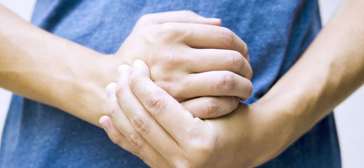 Closeup man holding his wrist pain from using computer.