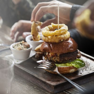 Plate of burger and fries served in a pub with people snacking